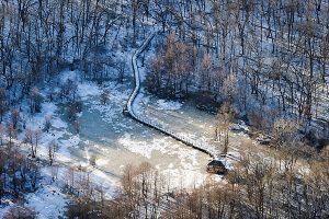 A boardwalk winds from the woods toward frozen Teal Pond and surrounding wetlands at the UW–Madison Arboretum. Photo: Bryce Richter/UW-Madison.