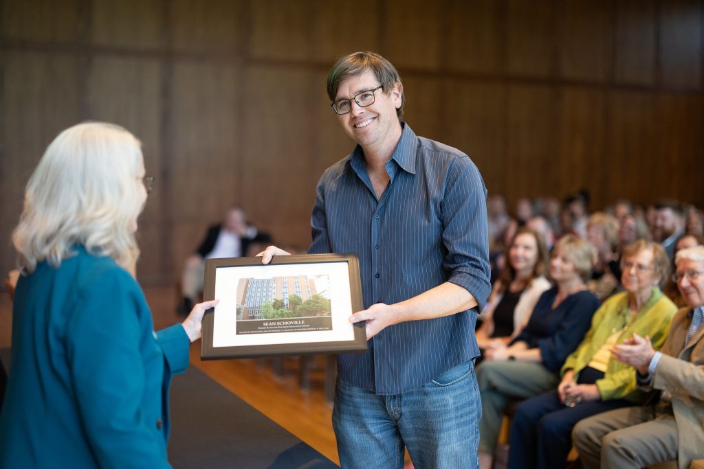man accepting award from woman