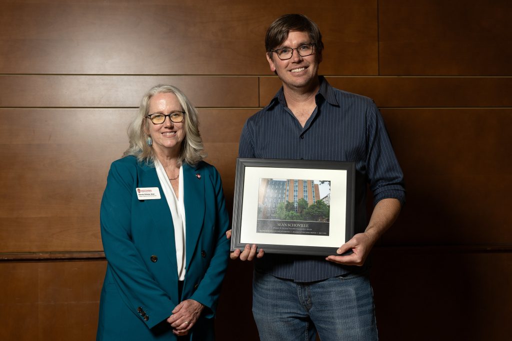 man holding award standing next to woman