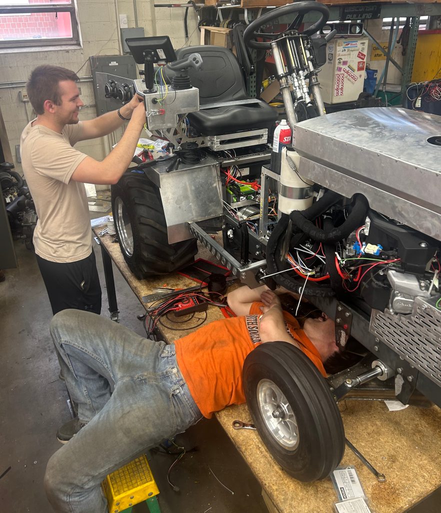 two men working on a tractor