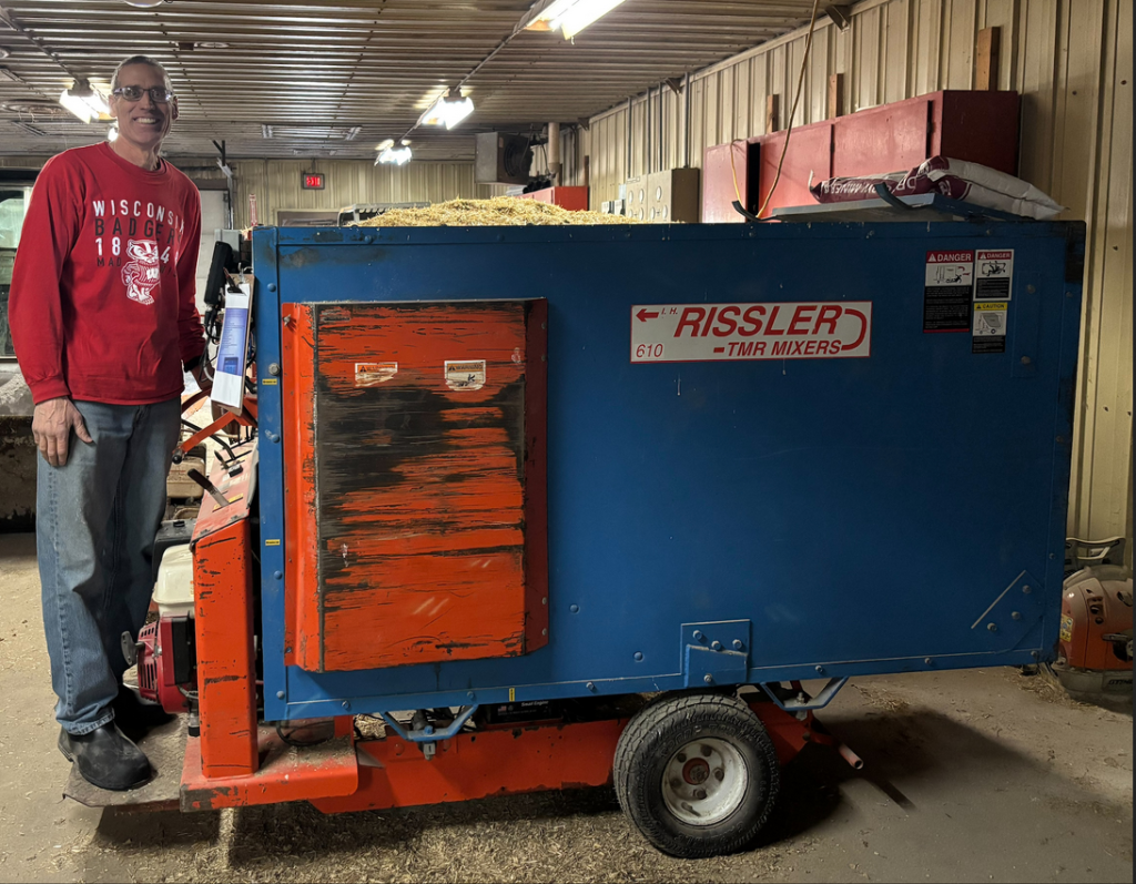 Man wearing red shirt and jeans standing on a feeder