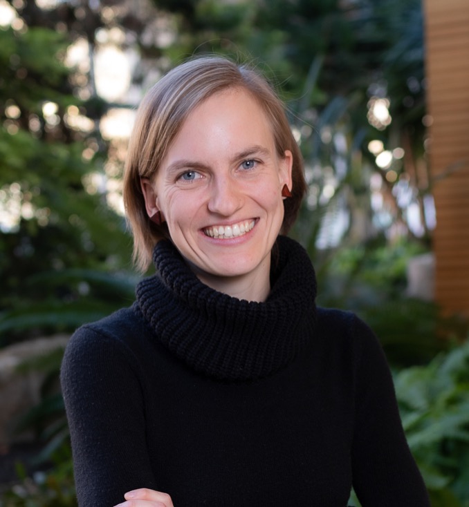 Smiling woman with blonde hair and black sweater looks at camera